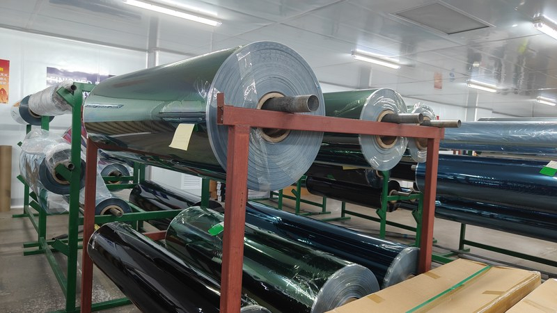 Finished window film rolls with batch labels stored on racks in the factory warehouse